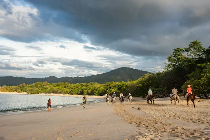 groupe de personne en randonnée à cheval sur la Playa Conchal à Guanacaste au Costa Rica