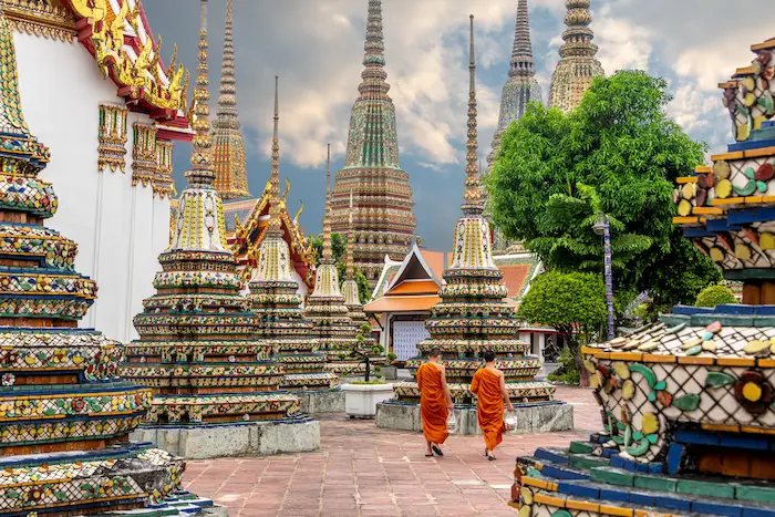 Deux moines marchant le long du chemin dans le temple Wat Pho à Bangkok